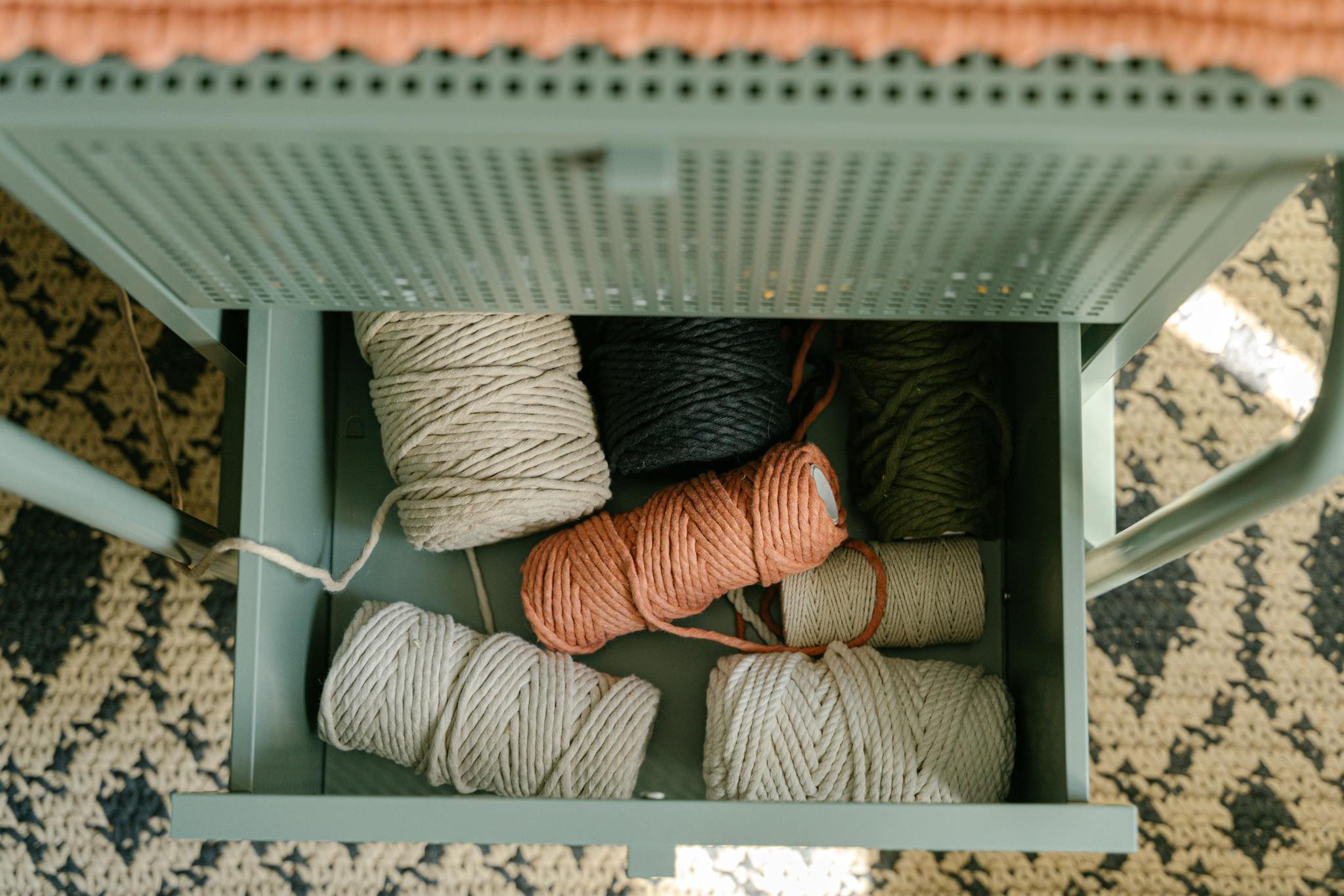 An organized assortment of colorful yarns in an open drawer viewed from above.