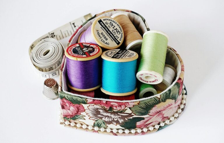 Collection of colorful sewing threads neatly arranged in a floral-patterned box, perfect for crafting inspiration.