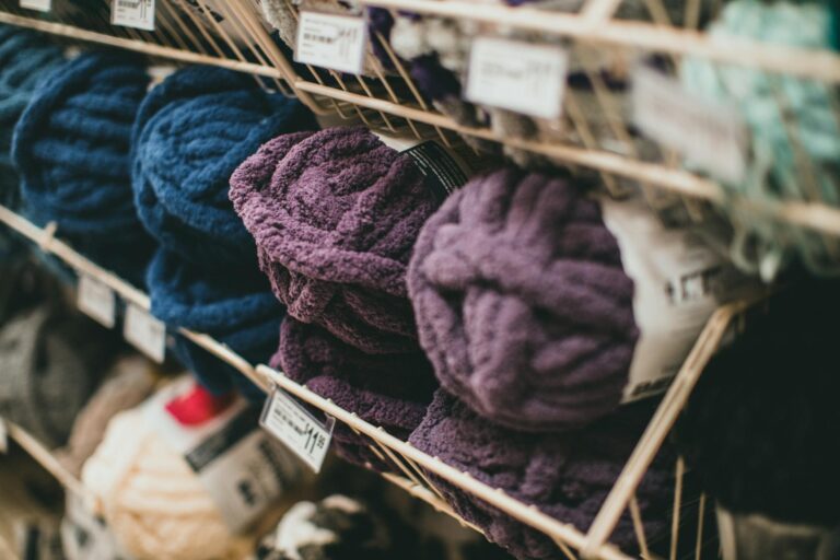 Colorful yarn balls arranged on racks in a store, showcasing texture and variety.