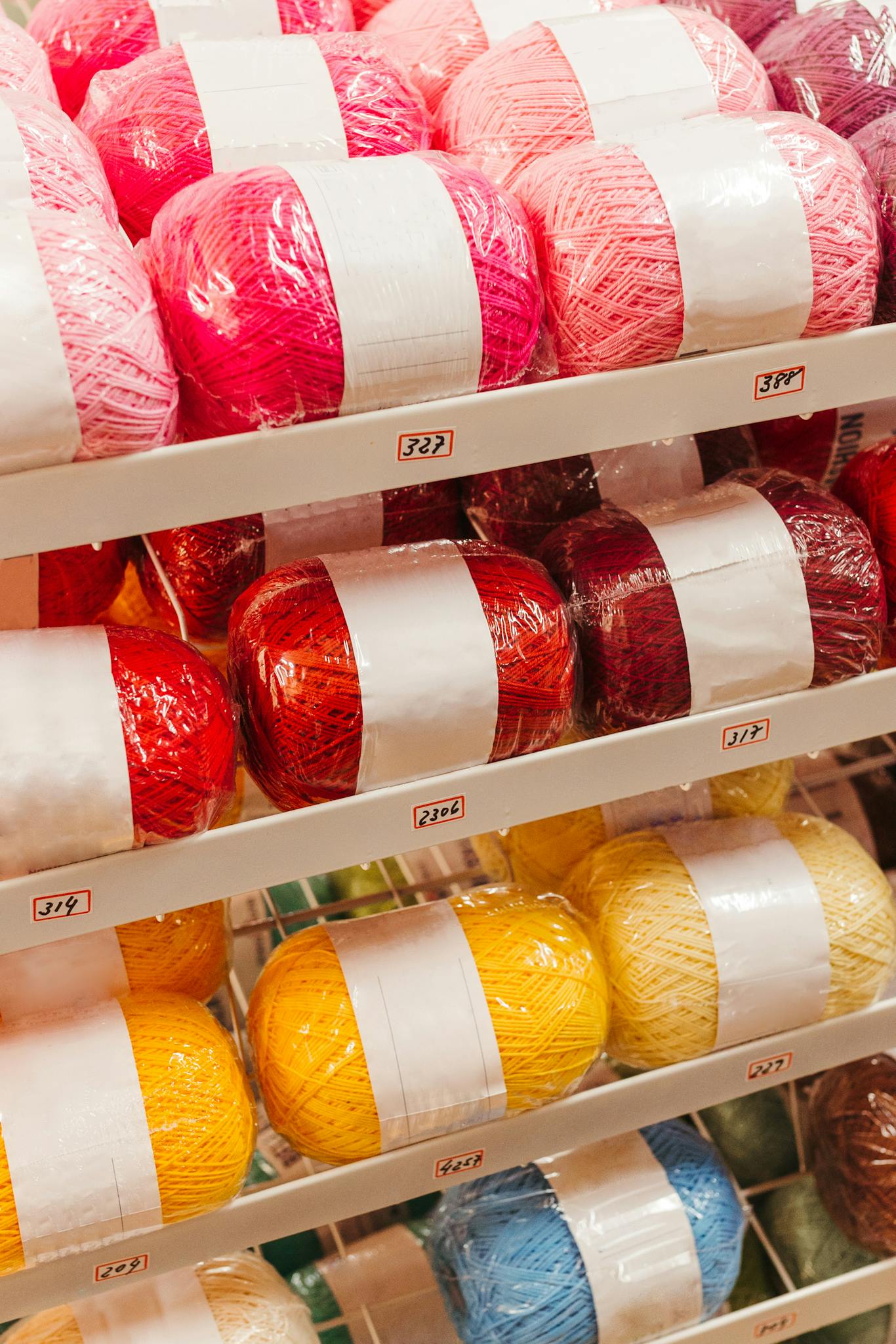 Vibrant yarn skeins in a shop, showcasing various colors for knitting and crochet projects.